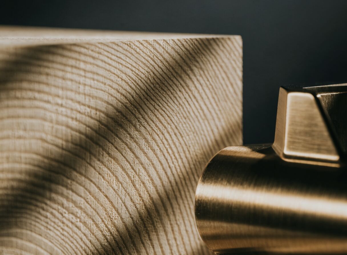 Macro photograph of oak grain beside a brushed brass fitting